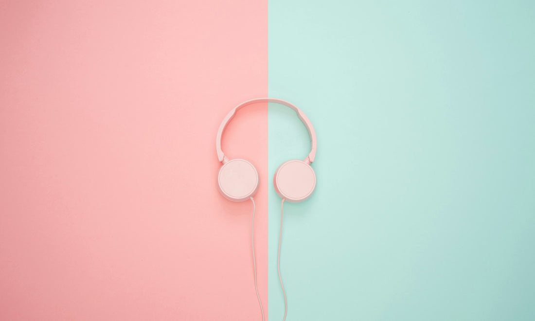White headphones on a split pink and mint background
