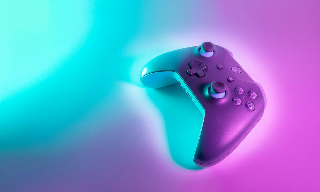 Game controller lit by neon cyan and magenta light