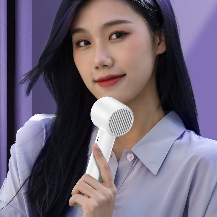 Woman using a Magnussen FN2 handheld Airflow fan