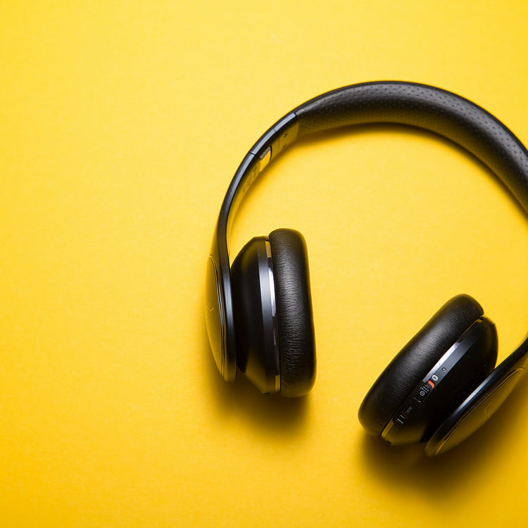 Black over-ear headphones on a yellow background