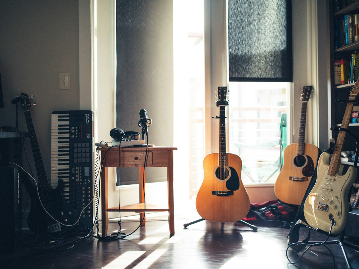 Home music studio with guitars and a keyboard in natural light